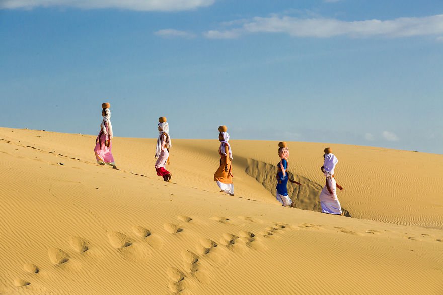 Những người phụ nữ đội nước đi trên cồn cát sa mạc ở Phan Rang.